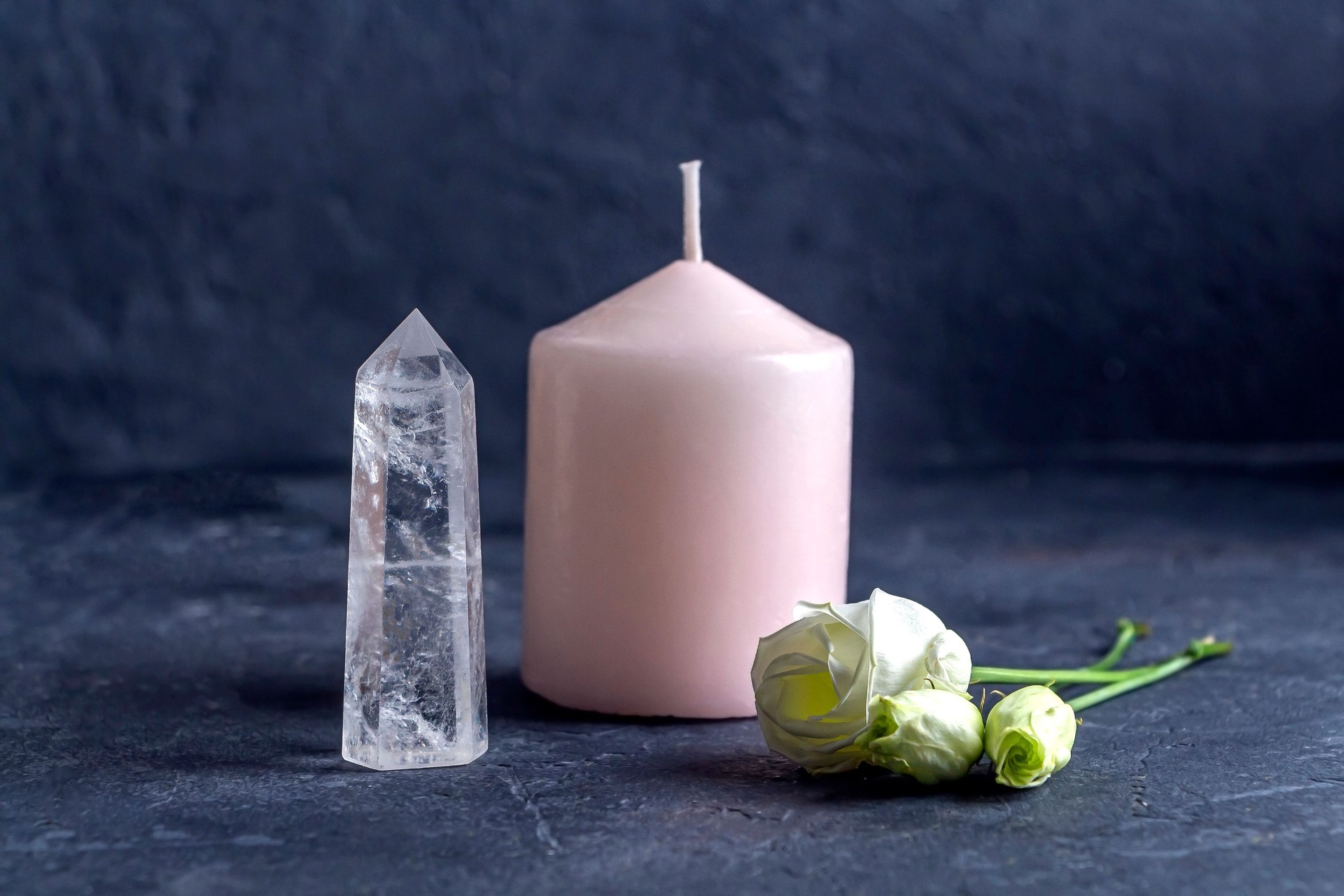 Magic vintage still life with crystals, pink candle and rose flowers. Meditation reiki. Ritual for love and chakra balance. Esoteric and pagan rituals, witchcraft Wiccan or spiritual practice (healing).